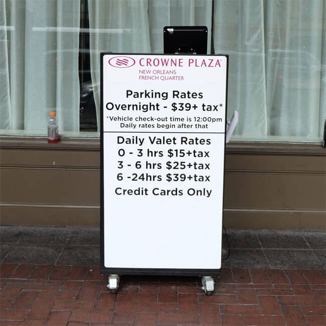 Parking rate sign at the Crowne Plaza Hotel, Canal Street, New Orleans. Parking Rates: Overnight - $39+tax. Vehicle checkout time is 12:00 pm. Daily rates begin after that. Daily Valet Rates: 0-3 hrs $15+tax. 3-6 hrs $25+tax. 6-24 hrs $39+tax. Credit cards only.