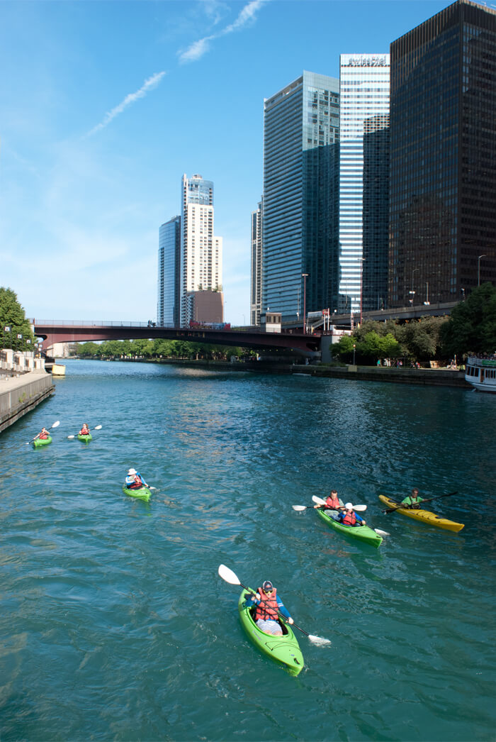 six kayaks paddle along the Chicago River
