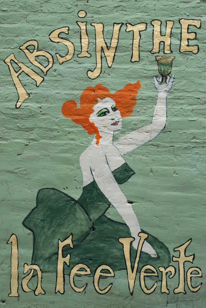 Painted mural on Chicago building. A woman holds up a glass of absinthe. Text reads "Absinthe la Fee Verte"