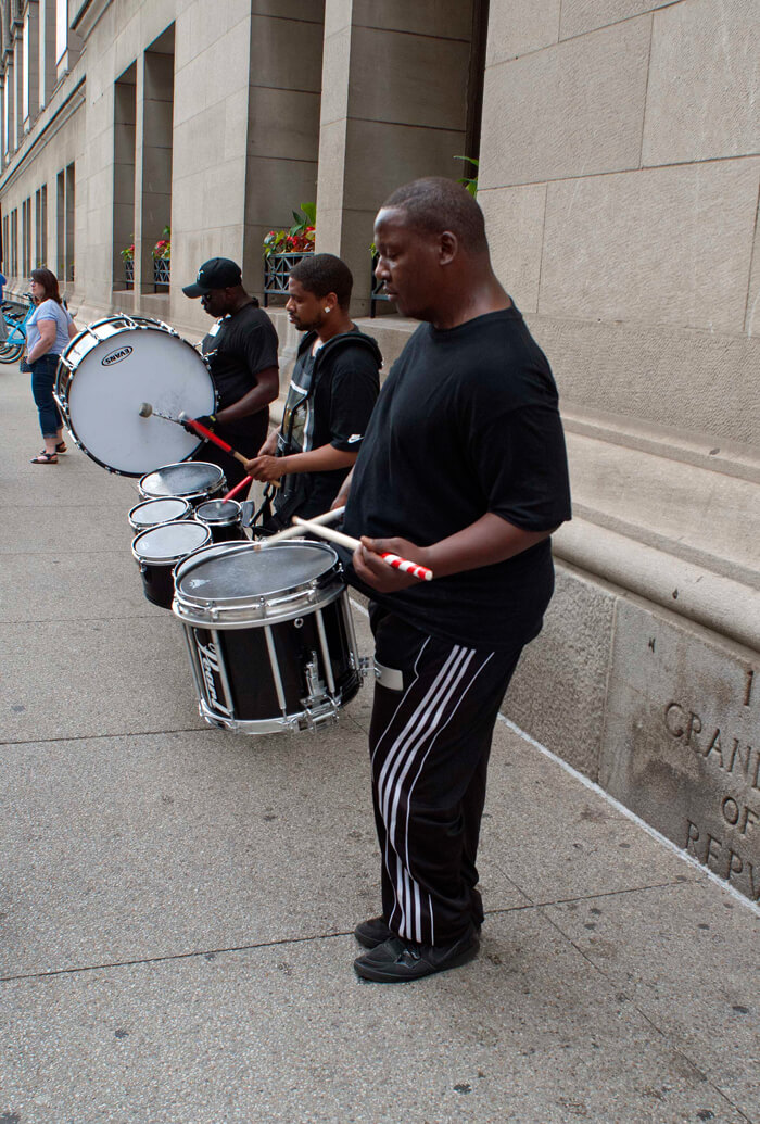 three drummers busk on Chicago street