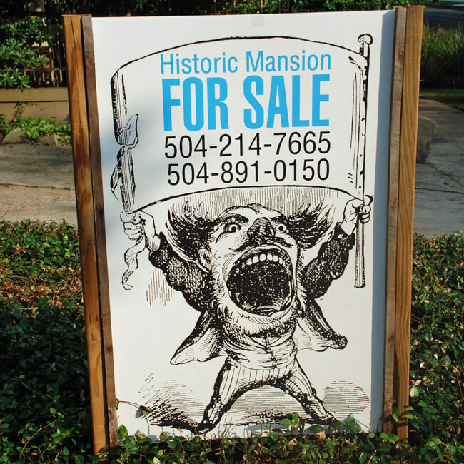 for sale sign showing an impish man screaming. Text reads "Historic Mansion for sale 504-214-7665 504-891-0150"
